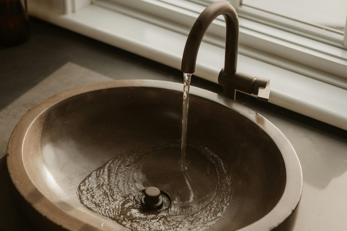 Water flowing into a bronze sink basin